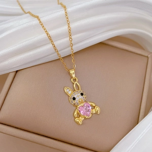 Detail of pink heart crystal rabbit pendant with sparkling zircon on a gold chain