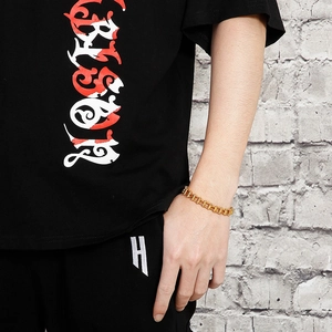 Detailed close-up of a men's heavy gold titanium steel bicycle chain link bracelet