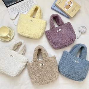 Close-up of colorful plush fleece tote bags with woven labels on textured fabric
