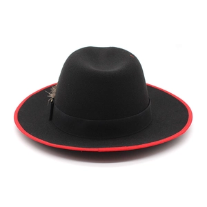 Detail of black wool fedora featuring red bound edge and elegant feather decoration