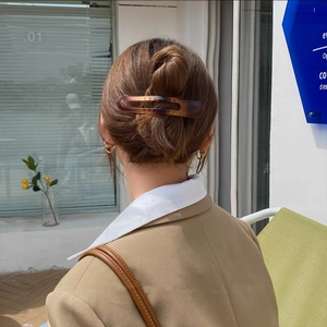 Close-up of tortoise shell pattern hair clip styled on a woman's bun hairstyle