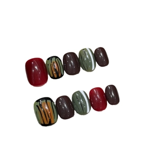 Handmade press-on nails set with retro autumn colors and glossy tiger stripe texture