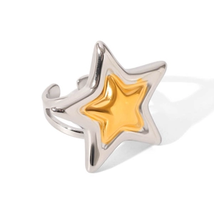 Macro detail of a two-tone star shaped ring featuring silver frame and golden inner star
