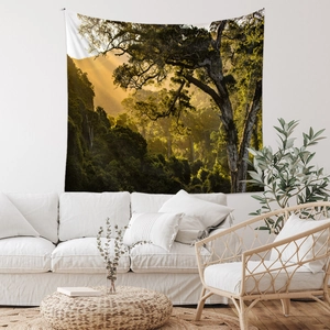 Detail of forest landscape tapestry hanging over a white sofa in a cozy room