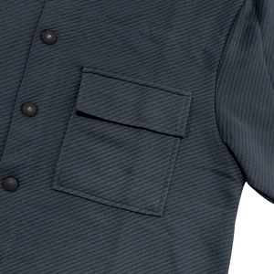 Detail of dark gray heavy twill jacket featuring front flap pocket and round smooth buttons