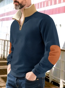 Detail view of the deep blue sweatshirt featuring contrast brown suede elbow patches