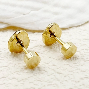 Macro detail of gold screw-back stud earrings with a polished flower petal design