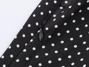 Macro view of black polka dot fabric featuring a high-quality hidden side zipper closure
