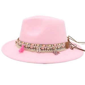 Detail of pink fedora featuring ethnic woven band with tassels and seashell ornaments