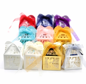 Laser-cut wedding favor boxes in various colors with ribbons and Mr & Mrs silhouettes