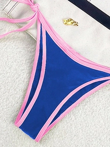 Detail of color block bikini bottom with gold wing ornament and side tie strings