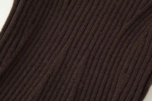 Détail macro du tissu en maille côtelée marron foncé montrant les motifs verticaux