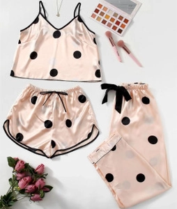 Flat lay of pink silk pajama set with black polka dots, camisole and pants with roses