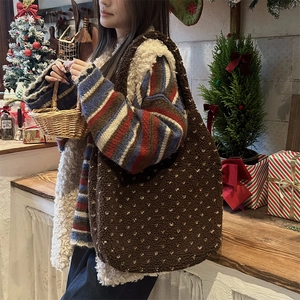 Détail du sac cabas en polaire marron à pois beige dans un décor de Noël chaleureux