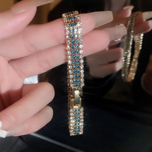 Detail of three-row gold bracelet with sparkling blue and white crystals and clasp
