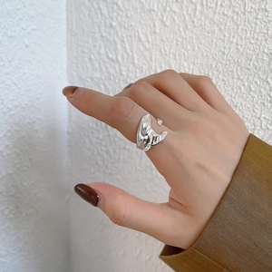 Close-up of irregular minimalist S925 sterling silver open ring on a finger