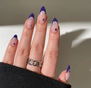 Detail of blue French almond press-on nails with silver heart and star glitter patterns