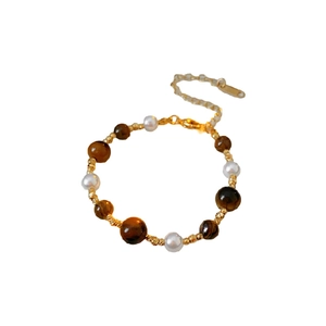 Gold plated beaded bracelet with tiger eye stones and pearls on white background