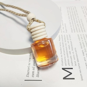 Car perfume glass pendant with wooden cap and golden essential oil for air freshening