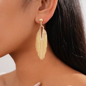 Detail of gold geometric hollow earrings with flowing mesh tassel on a model