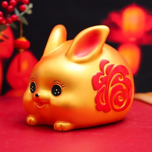 Close-up of golden Capybara resin ornament with red Fu character and festive background