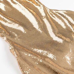 Detail von Goldpailletten auf einem Maxikleid mit schimmerndem Struktureffekt