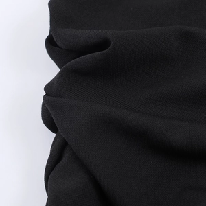 Détail rapproché d'un tissu en maille noire douce avec drapé naturel et texture fine