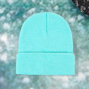 Close-up of bright turquoise knit beanie featuring classic rib texture and folded cuff