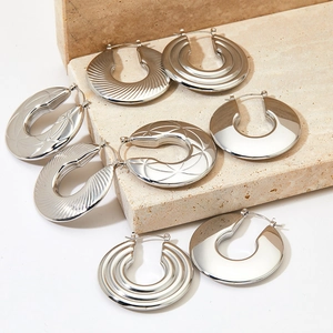 Polished stainless steel hollow hoop earrings with diverse geometric textures in silver