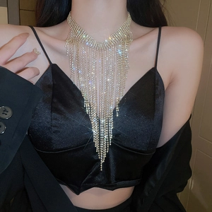 Close-up of a silver V-shaped rhinestone tassel necklace on a model for a luxury look