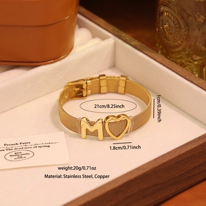 Détail du bracelet en maille d'acier doré avec lettre M et pendentif en cœur
