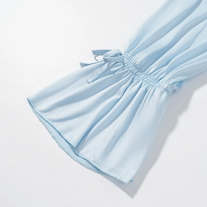 Detailed view of light blue chiffon flared sleeves with drawstring ribbons and ruffle cuffs