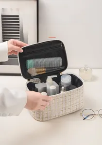 Close-up of tweed makeup bag with metallic zipper, mesh divider and large storage capacity