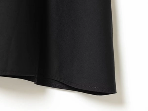 Detailaufnahme der Saumnaht und Stofftextur an einem schwarzen Strick-A-Linien-Kleid