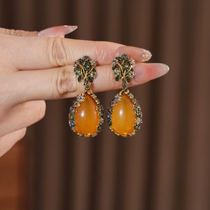 Macro detail of vintage court style drop earrings with amber stones and colorful crystals