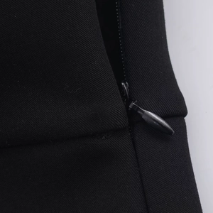 Nahaufnahme von schwarzem Köperstoff mit verstecktem Tropfen-Reißverschluss am Kleid
