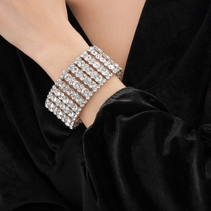 Gros plan d'un bracelet multi-rangs en diamants argentés sur un poignet sur velours noir