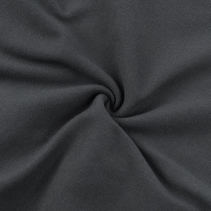 Gros plan sur la texture du tricot gris foncé montrant l'élasticité et la densité du tissu