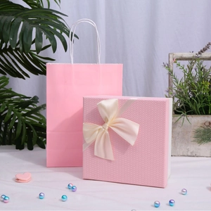 Elegant pink soap flower gift box and matching paper bag with a beige bow decoration