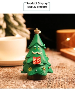 Close-up of cute resin Christmas tree figurine with golden star and gift box decoration
