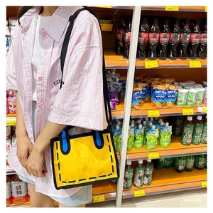 Detail view of yellow 2D cartoon style canvas tote bag worn by model in a daily scene
