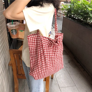 Chic red and white gingham canvas tote bag shown from a stylish side view on a model