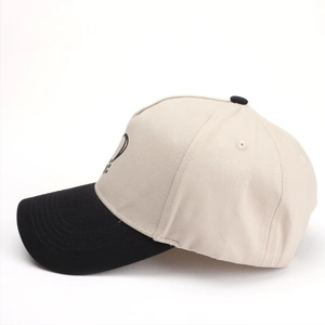 Détail de la casquette bicolore avec imprimé cœur et patte sur tissu sergé beige