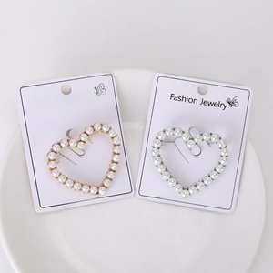 Detail of hollow heart brooches with pearls and rhinestones in gold and silver finish