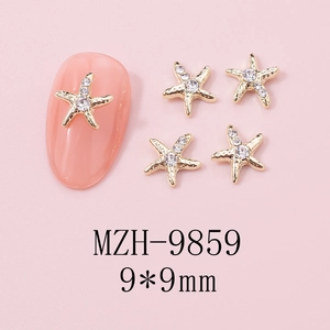 Detail of 9x9mm golden starfish nail charms with rhinestones on a pink base