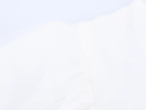 Gros plan sur la texture du tissu en maille blanche et les coutures de la robe