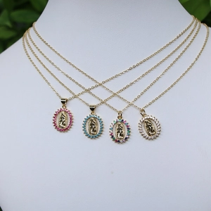 Gold Virgin Mary oval necklaces with colorful zircon stones on a white mannequin