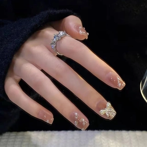 Elegant nude gradient press-on nails with silver glitter, pearls and bow accents