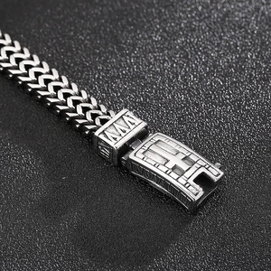 Détail d'un bracelet chaîne en acier inoxydable argenté avec boucle gravée