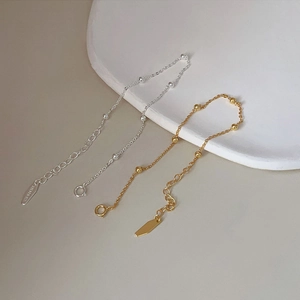 Detail view of minimalist gold and silver 925 sterling silver bead bracelets on white tray